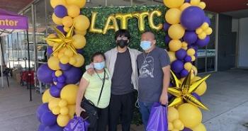 Family smiling in front of LATTC backdrop