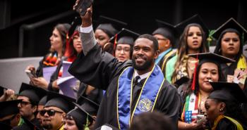 Graduating student waves to family