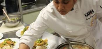 Student Serving a Dish in Kitchen