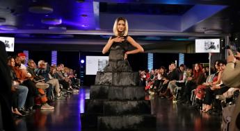 Model wearing black dress on runway