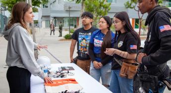 Representative speaks with four construction, maintenance and utilities students