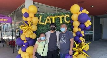 Student with parents in front of balloons and LATTC letters
