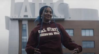Student wearing CSU Dominguez Hills sweatshirt in front of LATTC Building sign