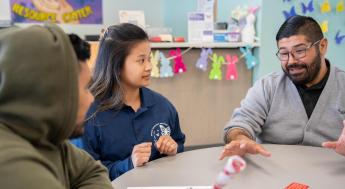 Dream Resource Center staffers assisting student at table 