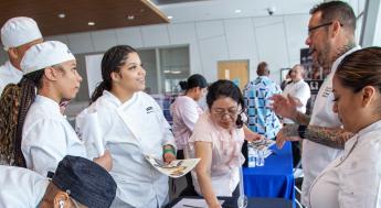 Culinary arts students listening to recruiter at job fair