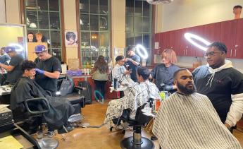 Barbers cutting clients' hair