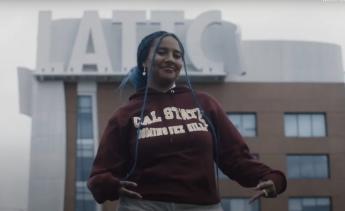 Student wearing CSU Dominguez Hills sweatshirt in front of LATTC Building sign