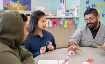 Dream Resource Center staffers assisting student at table 