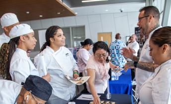 Culinary arts students listening to recruiter at job fair