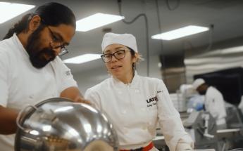 Culinary Arts student watching instructor in kitchen
