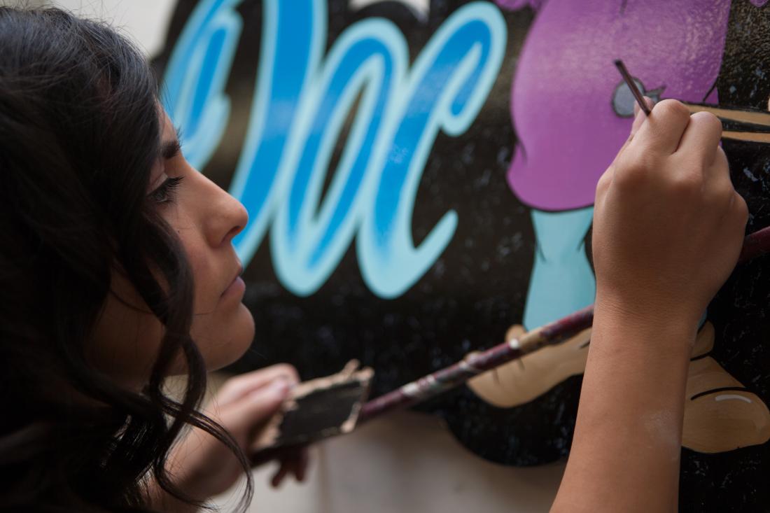 Girl Painting Over a Mural