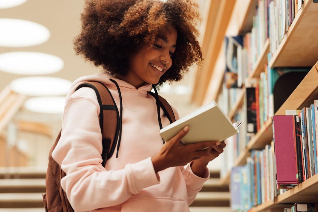 Student reading book at library
