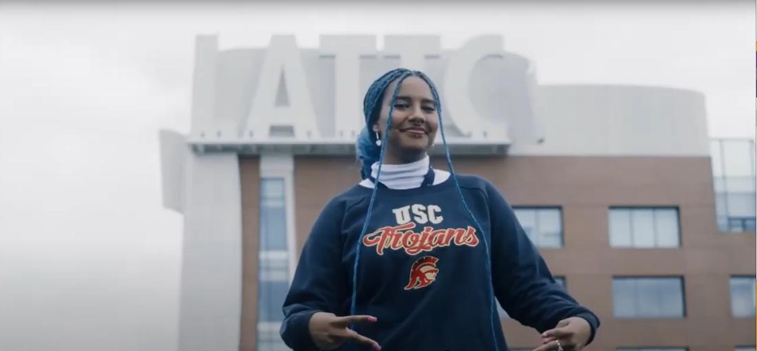 Student wearing USC sweatshirt in front of LATTC building sign