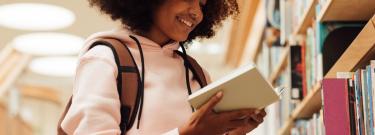 Student reading book at library