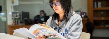 Student wearing UCLA sweatshirt browsing admission brochure
